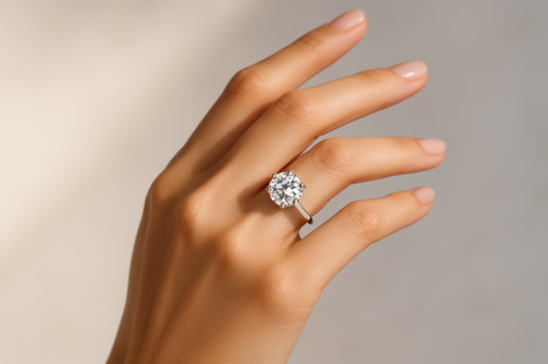 High-quality image of a model hand gracefully posed, wearing a sparkling lab-grown diamond ring. Focus on the ring’s brilliance with sharp reflections and fine details. Background should be clean, soft neutral tones with subtle gradient accents for a premium feel. Keep the look elegant, minimal, and luxurious